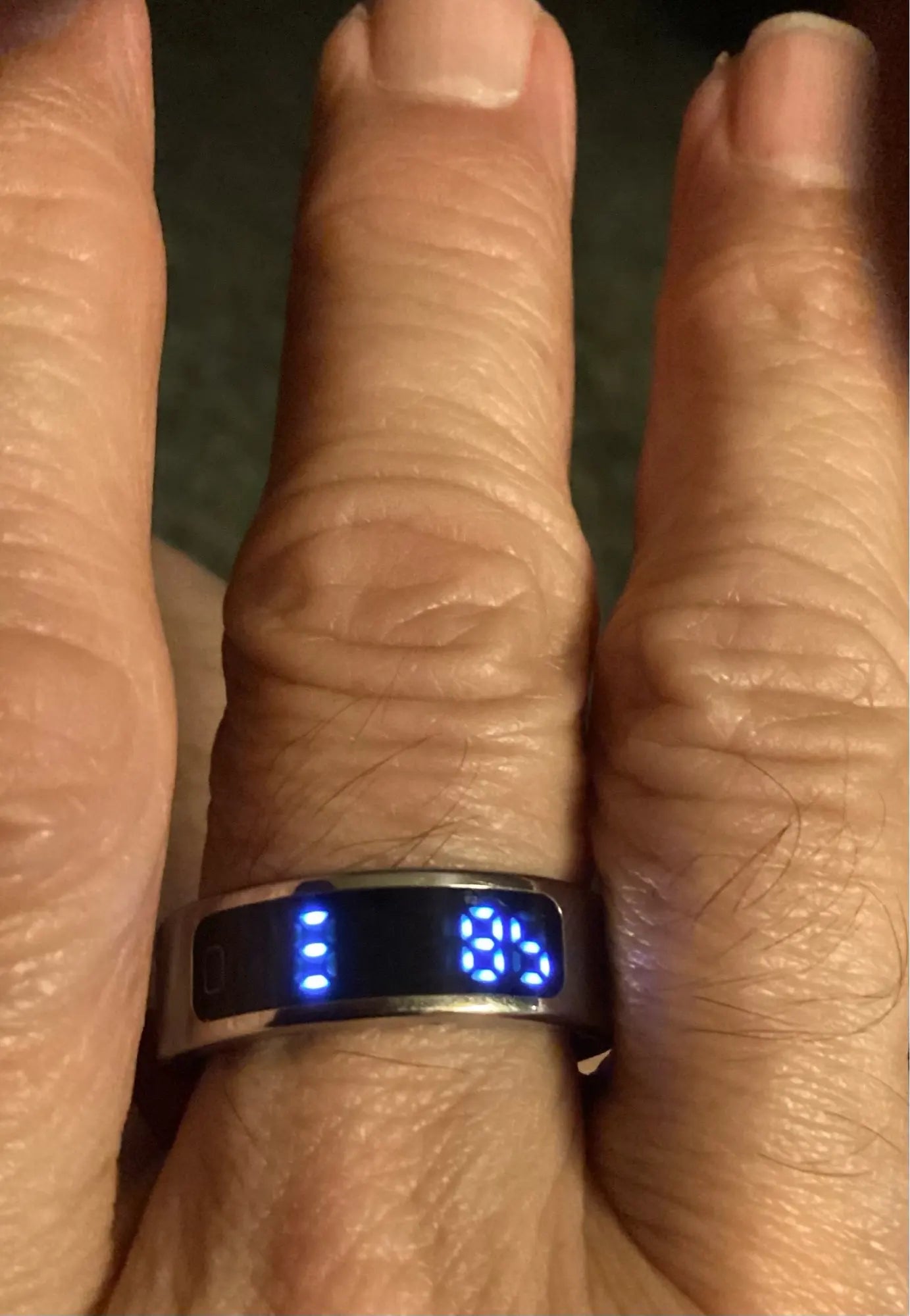 Smart ring on finger showing LED display